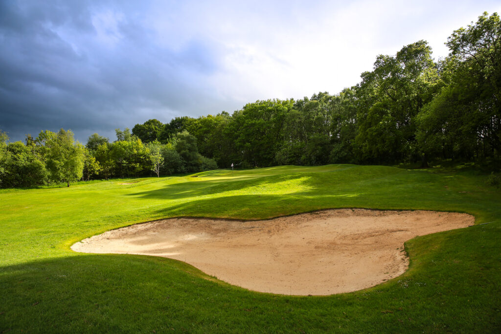 Hole with bunker and trees around at Macdonald Linden Hall Golf Course