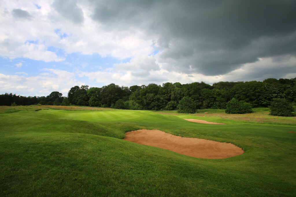 Hole with bunker and trees around at Mottram Hall Golf Course