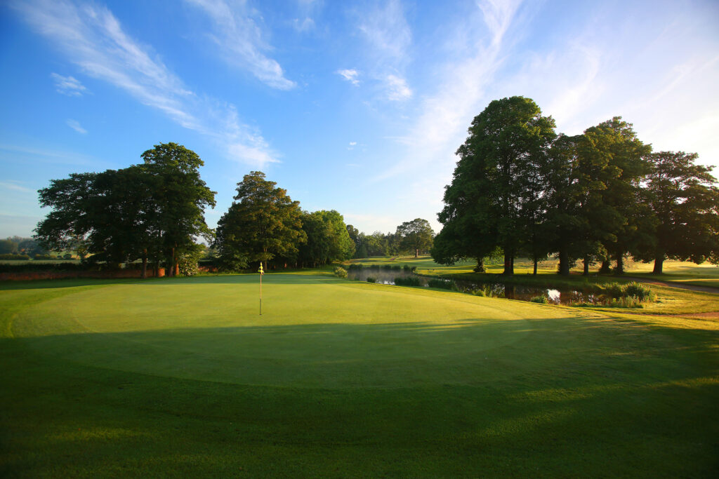 Hole with trees and water hazard at Mottram Hall Golf Course