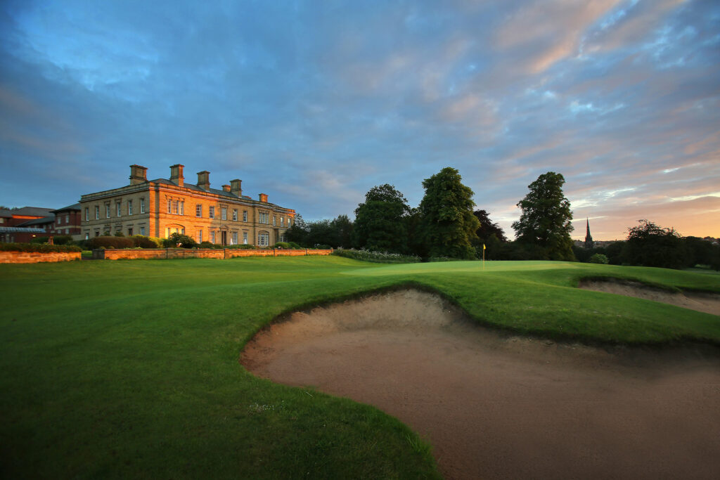 Hole with bunkers at Oulton Hall Golf Club with trees around and building in background