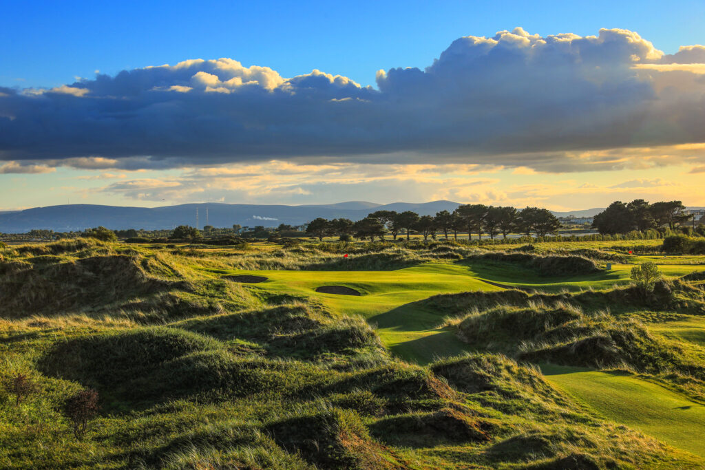 Hole with bunkers at Portmarnock Golf Club with trees in distance