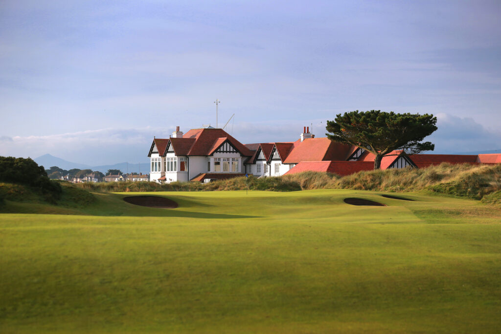 Hole with bunkers at Portmarnock Golf Club with building in background