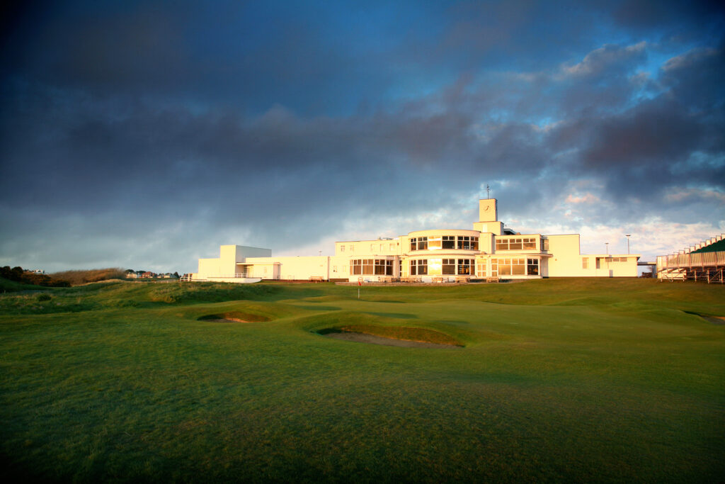 Fairway with hole with red flag and bunkers at Royal Birkdale with building in background