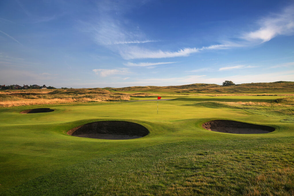 Hole with red flag and bunkers at Royal Liverpool Golf Club