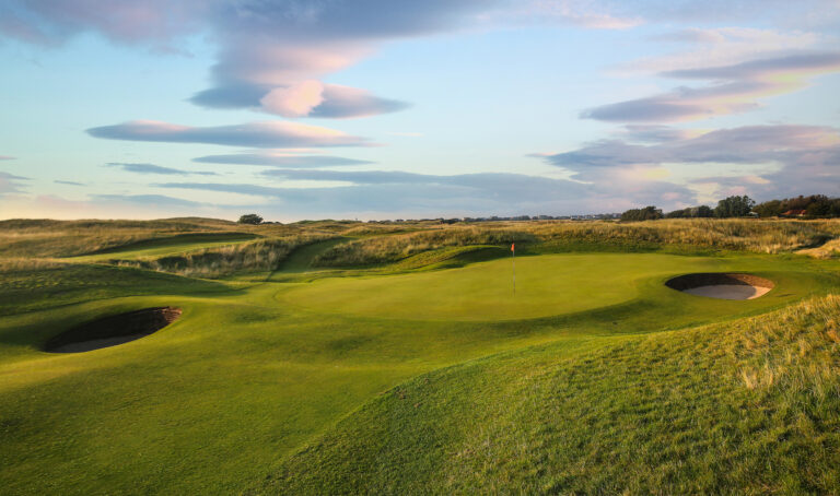 Hole with red flag and bunkers at Royal Liverpool Golf Club