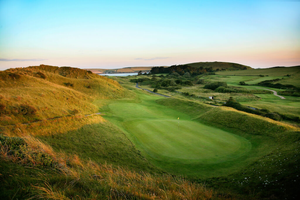 Hole with yellow flag with hills around at St Enodoc Golf Club - Church Course