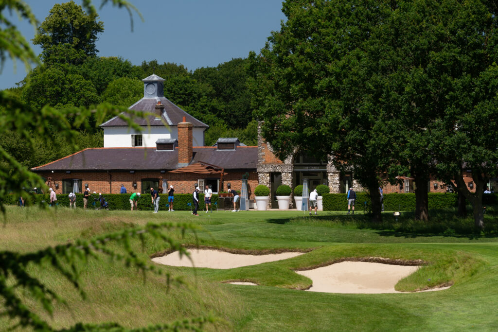 Bunkers on fairway at The Grove - Championship with building and people in background