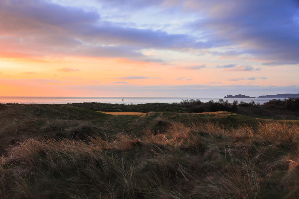 Hole with mounds around at The Island Golf Club at sunset