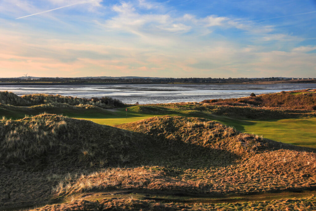 Hole with mounds around and ocean in background at The Island Golf Club