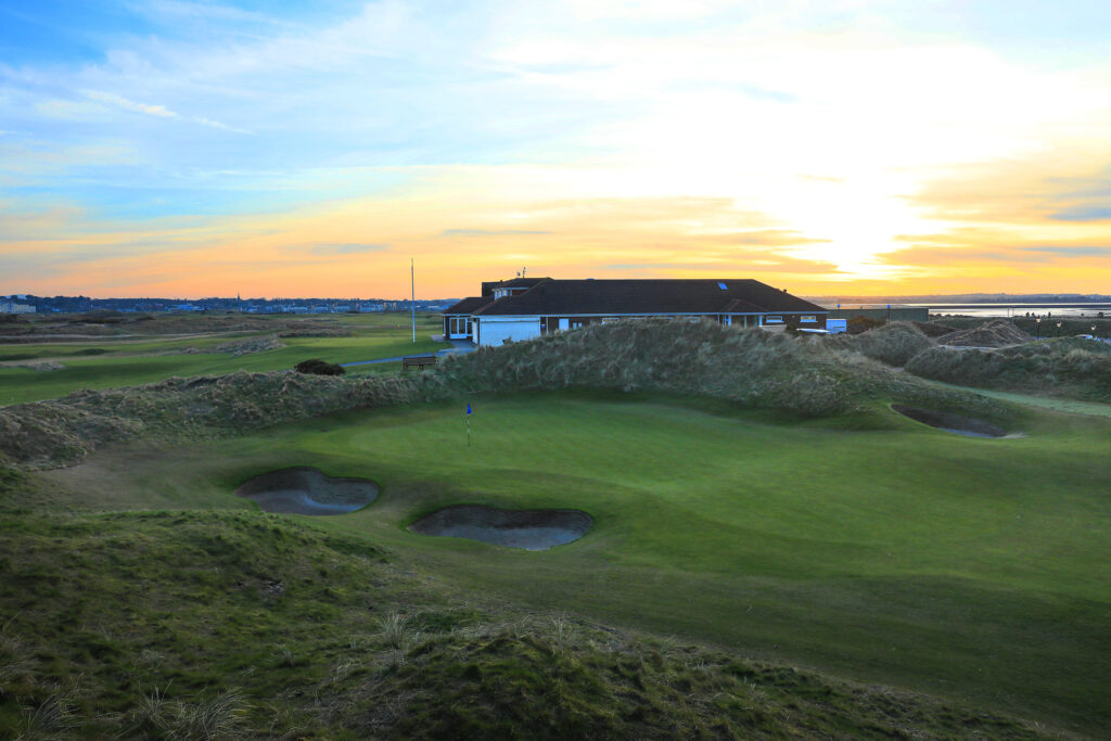 Hole with bunkers at The Island Golf Club with building in background