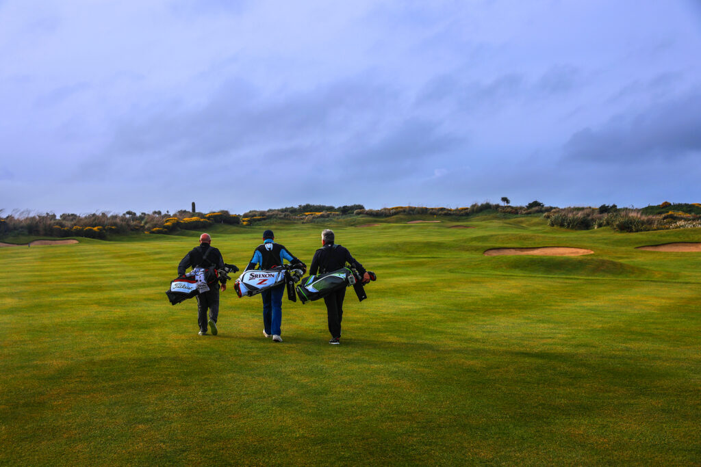 People carrying their bags across the fairway at Old Head Links