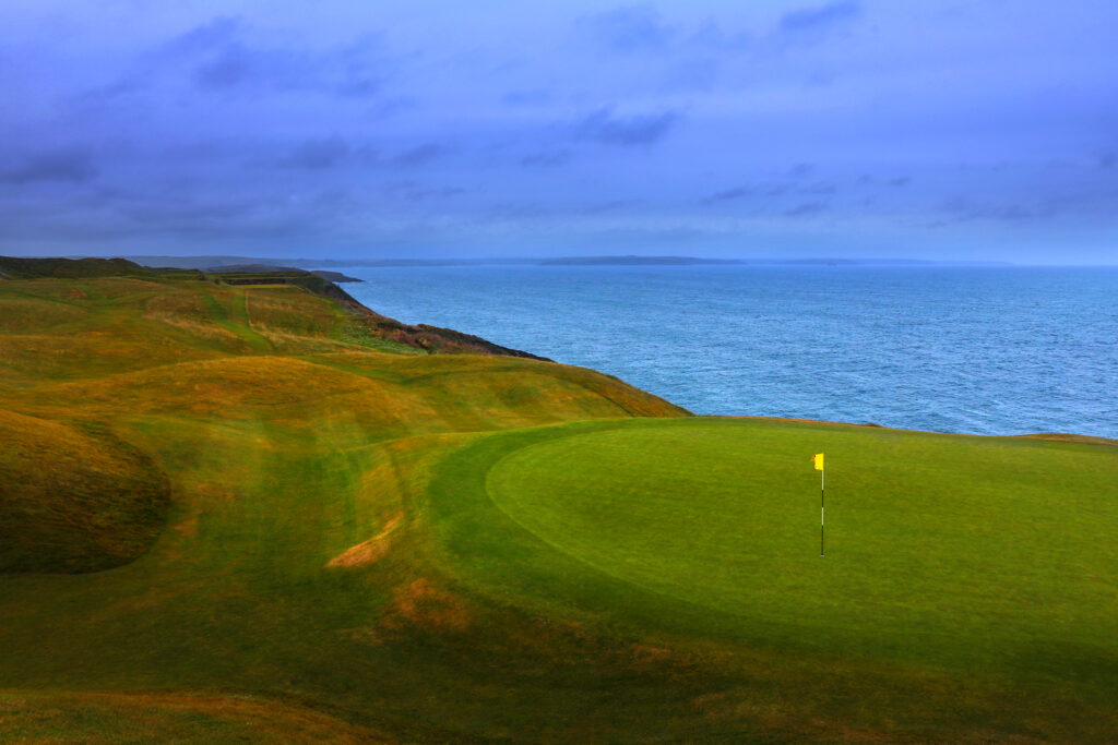 Hole with yellow flag at Old Head Links with ocean view