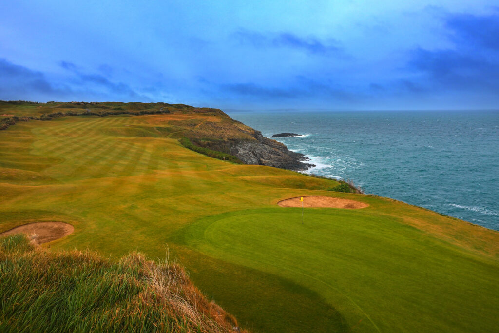 Hole with yellow flag and bunkers at Old Head Links with ocean view