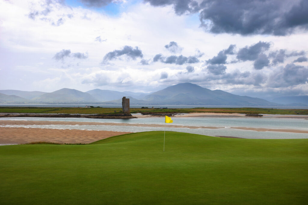 Hole with yellow flag at Tralee Golf Club with ocean view