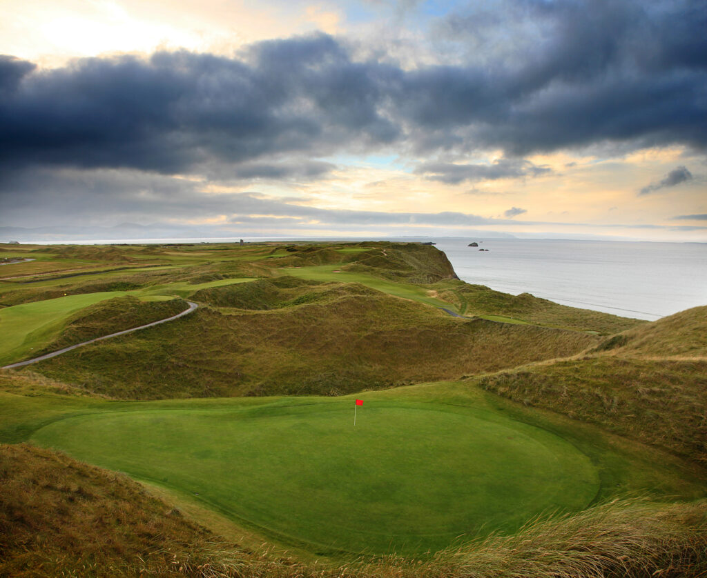 Hole with red flag at Tralee Golf Club with ocean view