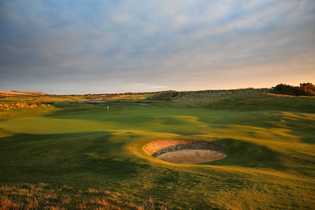 Hole with white flag and bunker at Championship Course at Trevose Golf & Country Club