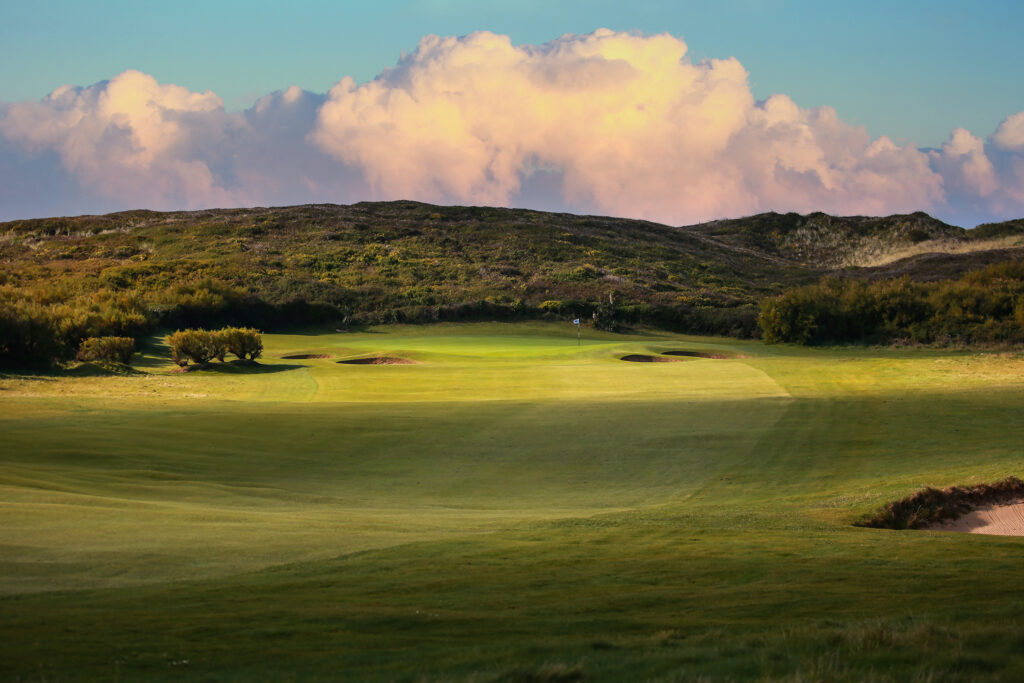 Fairway with hole with white flag with hill in background at Championship Course at Trevose Golf & Country Club