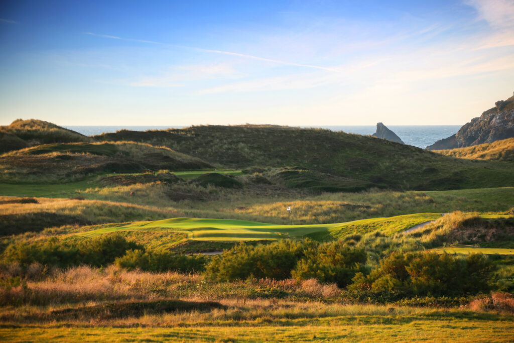 Fairway at Championship Course at Trevose Golf & Country Club with hills around and hole with white flag in distance