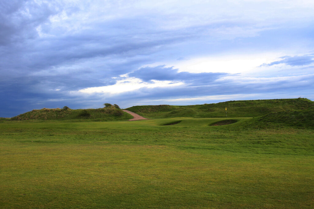 Fairway with hole with yellow flag atWest Lancashire Golf Club with bunkers