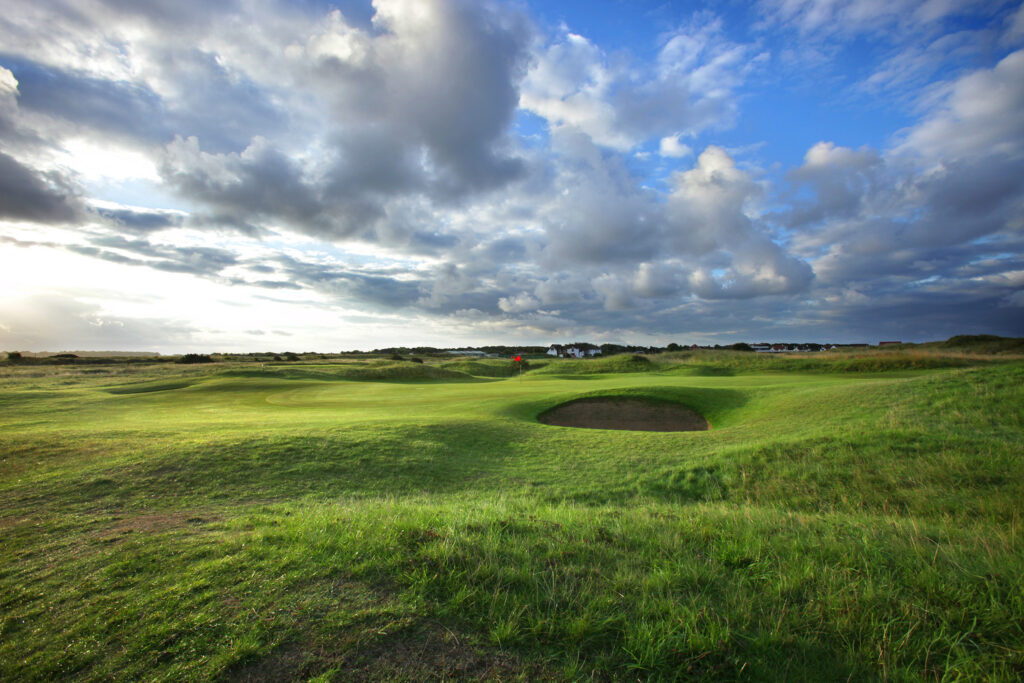 Hole with red flag with bunker at West Lancashire Golf Club