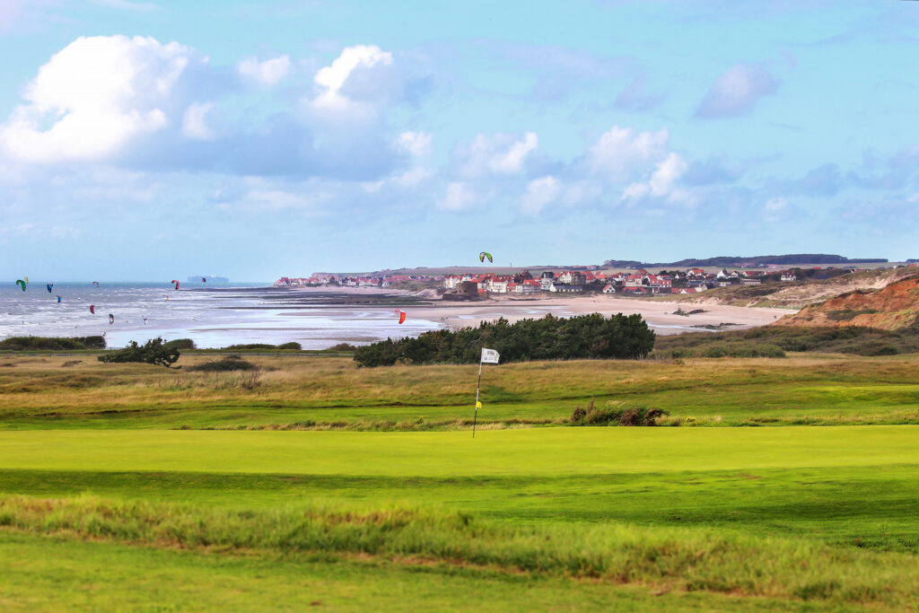 Hole at Wimereux Golf Course with ocean in background with kites around