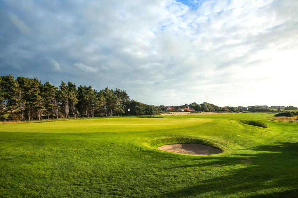 Hole with bunkers at Wimereux Golf Course with trees in background