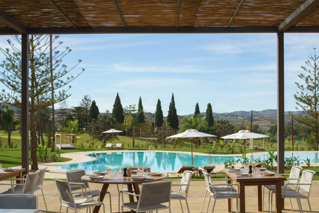 Outdoor dining with pool view at La Zambra Resort