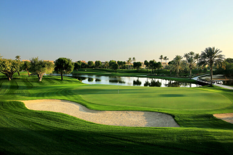 picture of a golf course in abu dhabi with a lake in the middle of the golf course