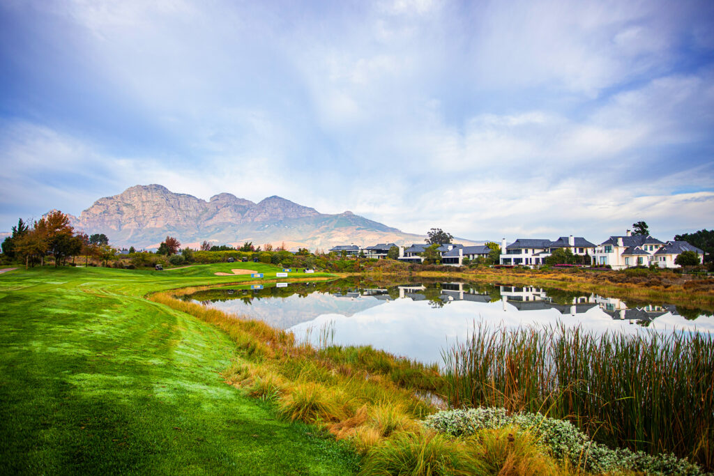 Lake on fairway at Pearl Valley Golf Course with buildings and mountains in distance