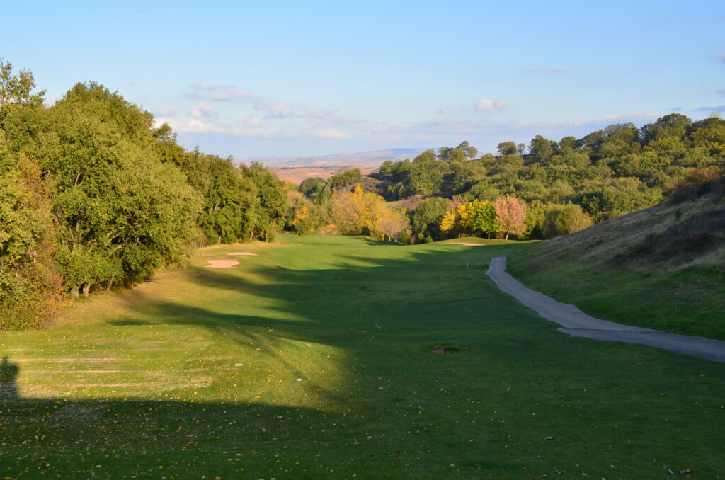 picture of rioja alta golf course with trees and a side walk on the right