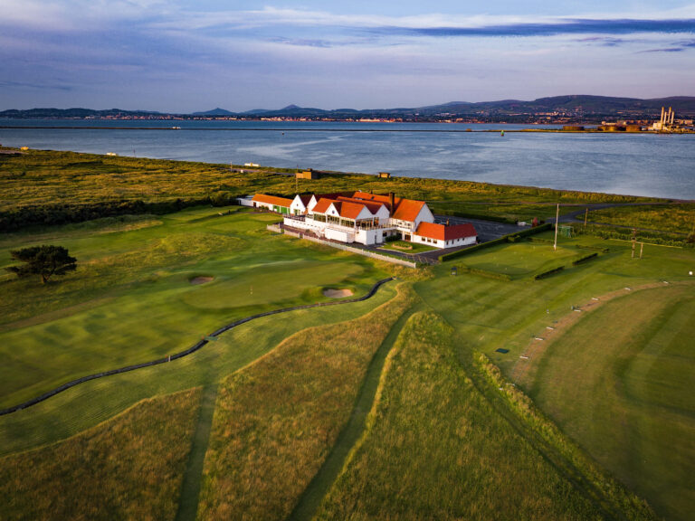 Building at Royal Dublin Golf Club with ocean in background