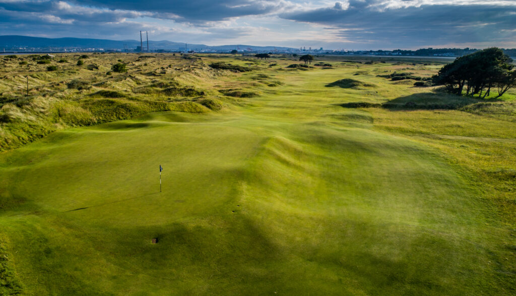 Hole at Royal Dublin Golf Club with mounds and trees around