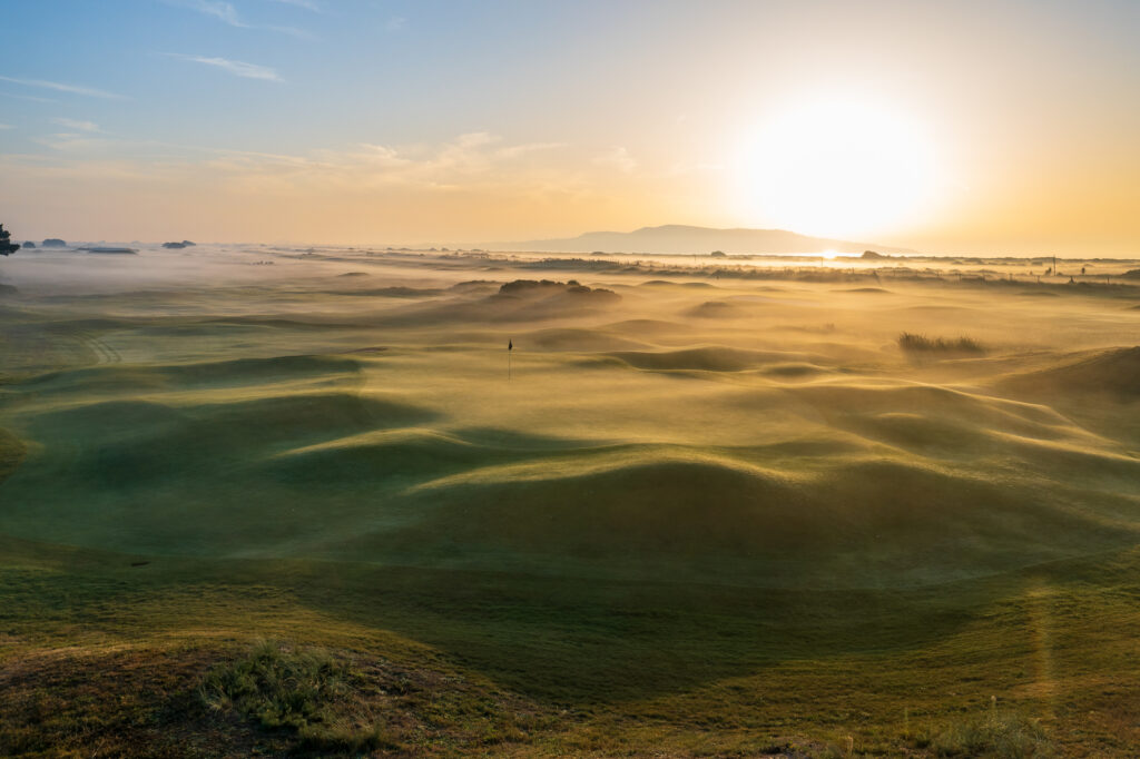 Hole at Royal Dublin Golf Club with the sun shining through the mist