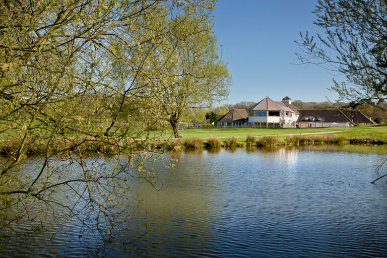 Lake on fairway at Sandford Springs with building in distance