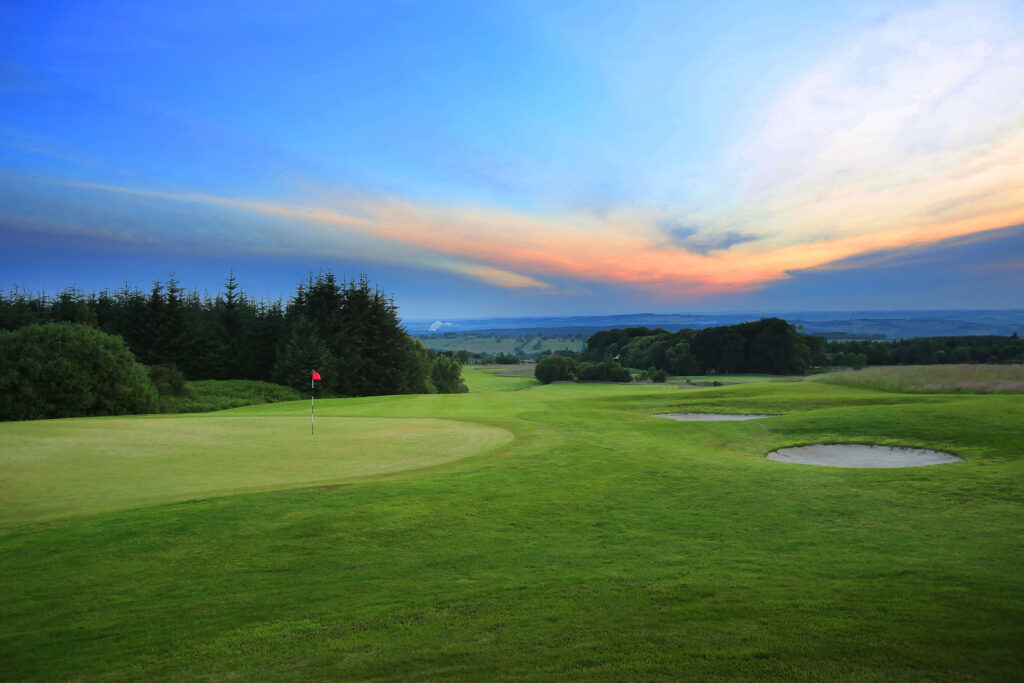 Hole with red flag and bunkers at Slaley Hall - Priestman Course with trees around