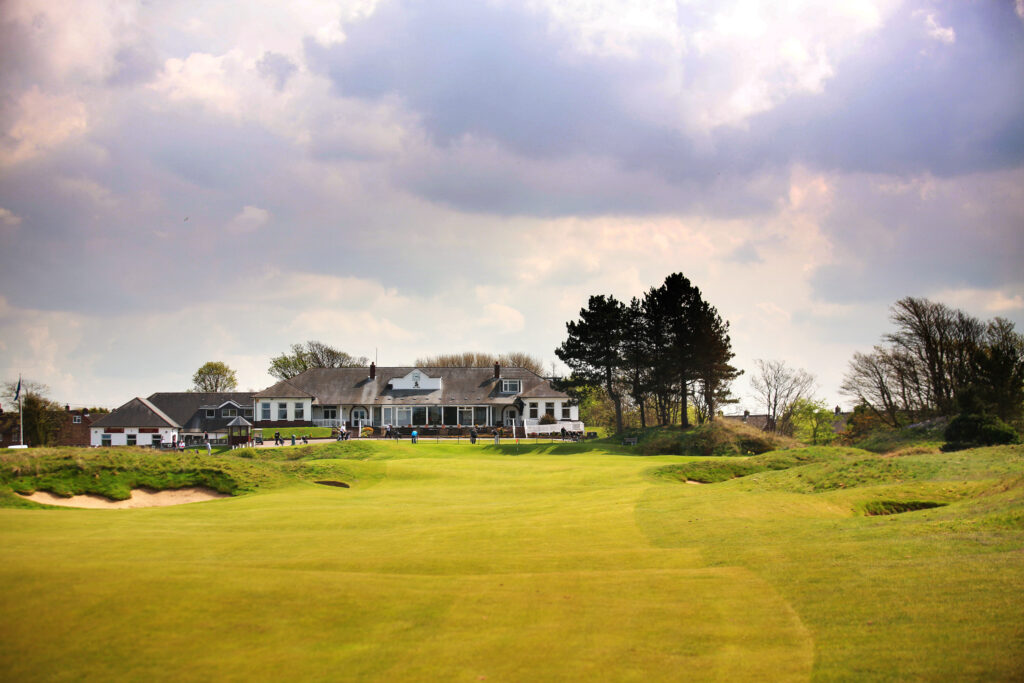 Building at Southport & Ainsdale with trees around and people playing golf