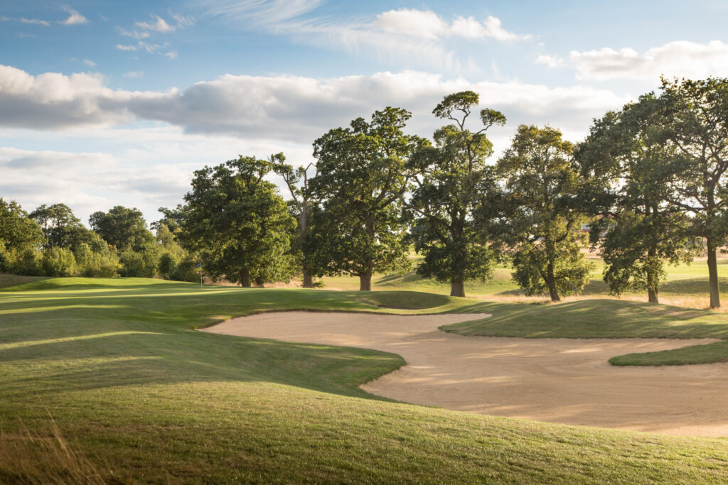 Hole with bunker at The Oxfordshire with trees around