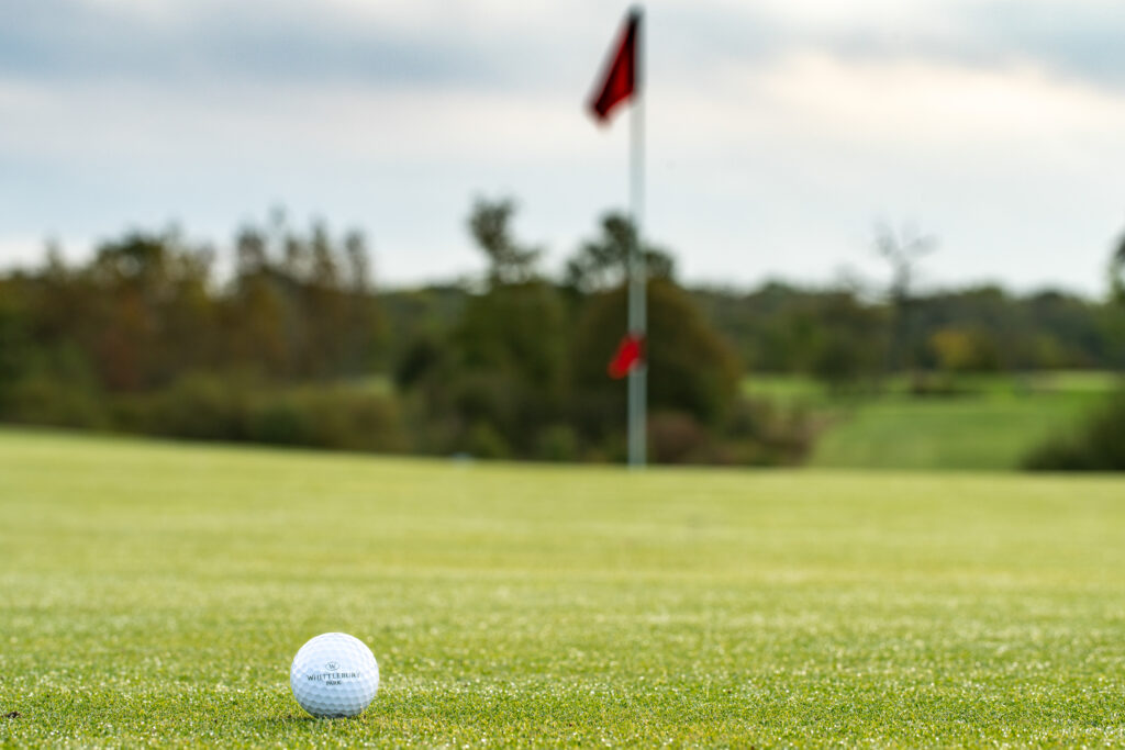 Ball on the green with a red flag at Whittlebury Park Golf Course