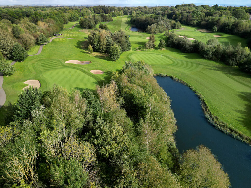 Aerial view of lake on fairway at Worsley Park Golf Course with trees around