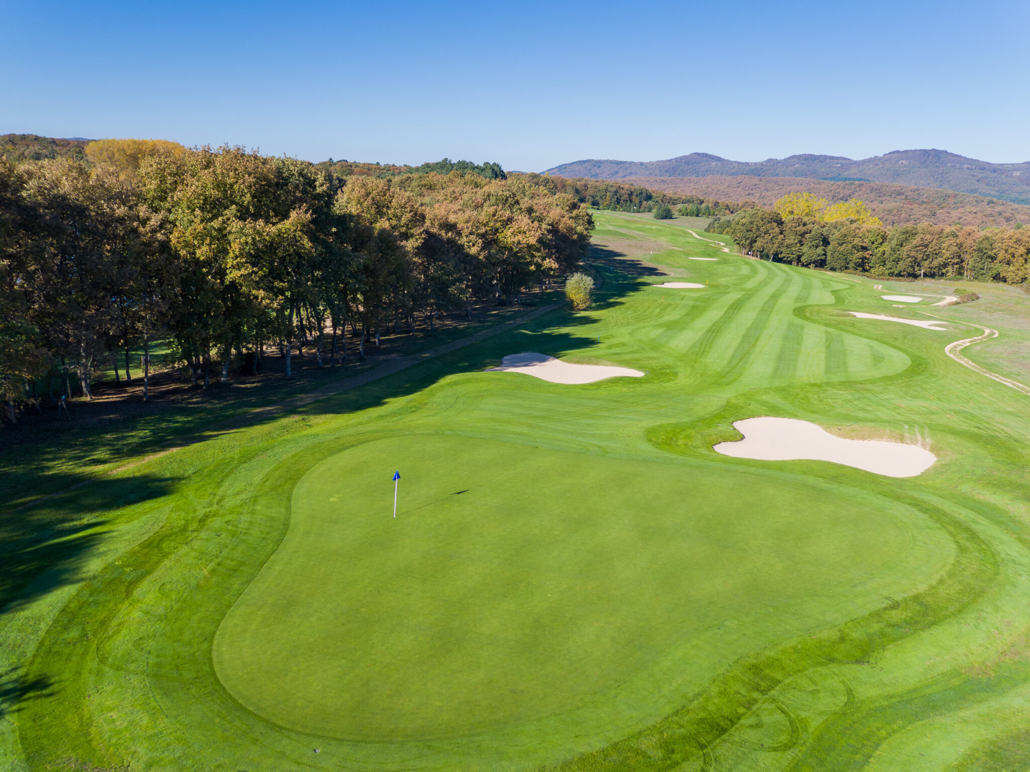 Aerial view of a hole at Izki Golf Club with bunkers and trees around