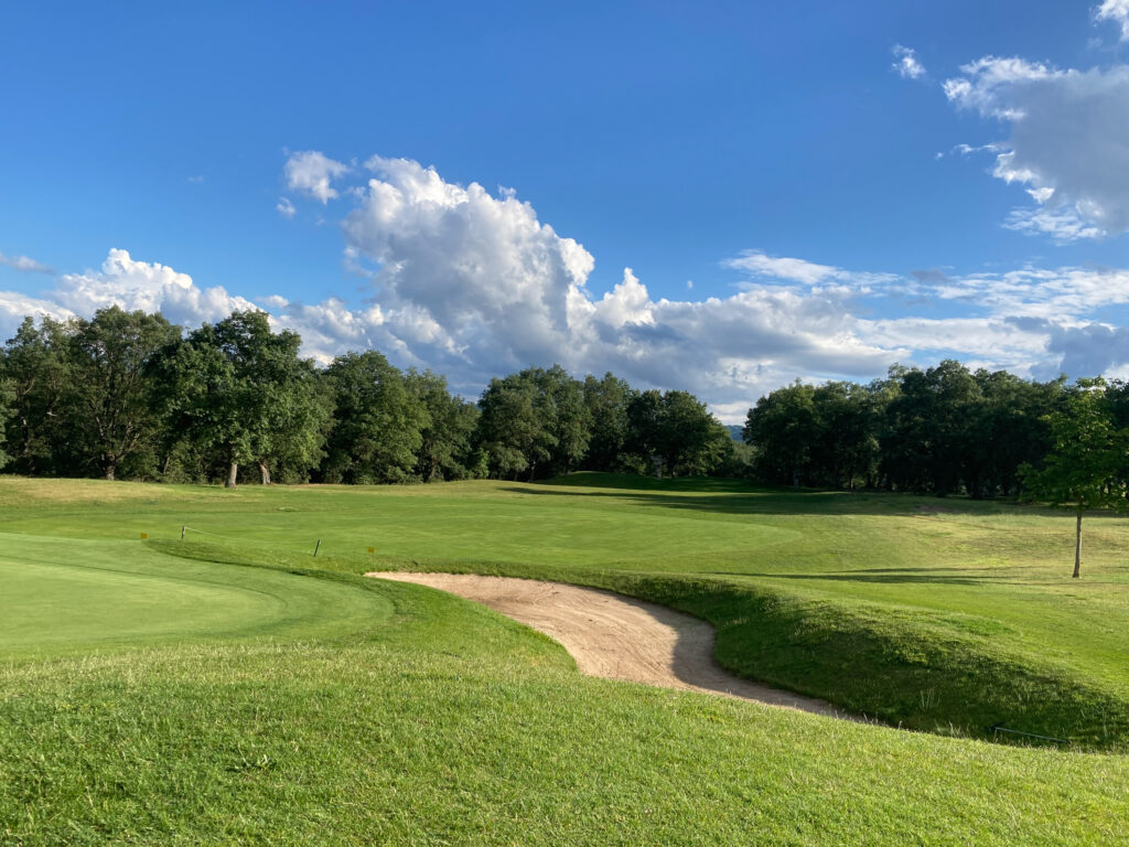 Hole with bunker at Rioja Alta Golf Club with trees around