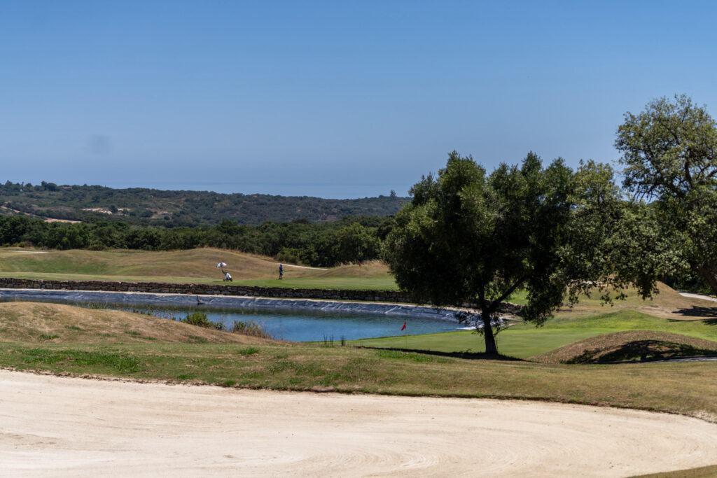 Bunker on fairway at San Roque Golf & Resort with trees and lake in background