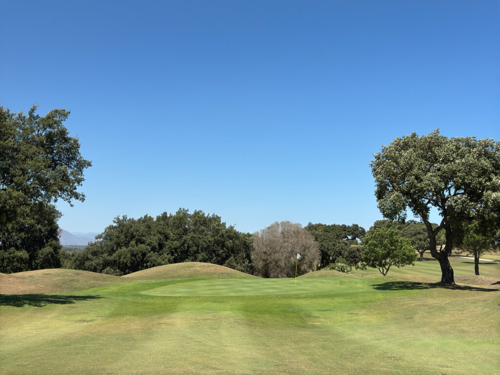 Hole with trees around at San Roque Golf & Resort