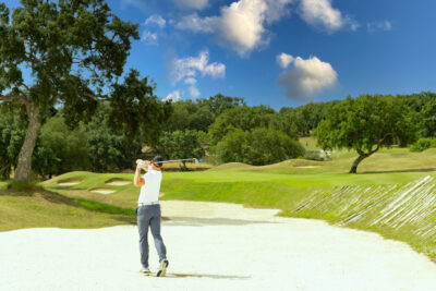 Person playing out of a bunker at San Roque Golf & Resort